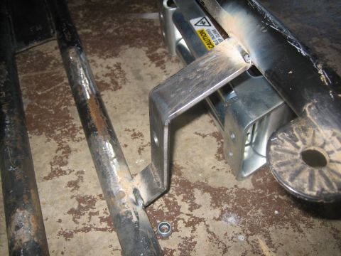 1995 Ford Bronco - Close-up of metal components, possibly part of a vehicle's undercarriage or frame, with a caution label.