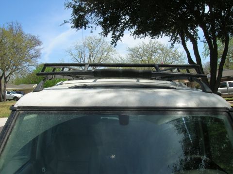 1999 Land Rover Discovery II - The top of a white SUV is shown with a large roof rack installed under a tree.