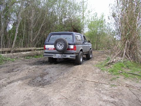 1989 Ford Bronco - This 1989 Ford Bronco is seen from the rear, navigating a muddy, wooded path.