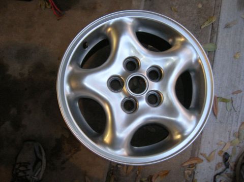 1999 Land Rover Discovery II - A single alloy wheel with a five-spoke design rests on a concrete surface.