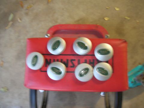 1999 Land Rover Discovery II - Seven Land Rover center caps are displayed on a red Craftsman toolbox, suggesting they are parts for sale or storage.