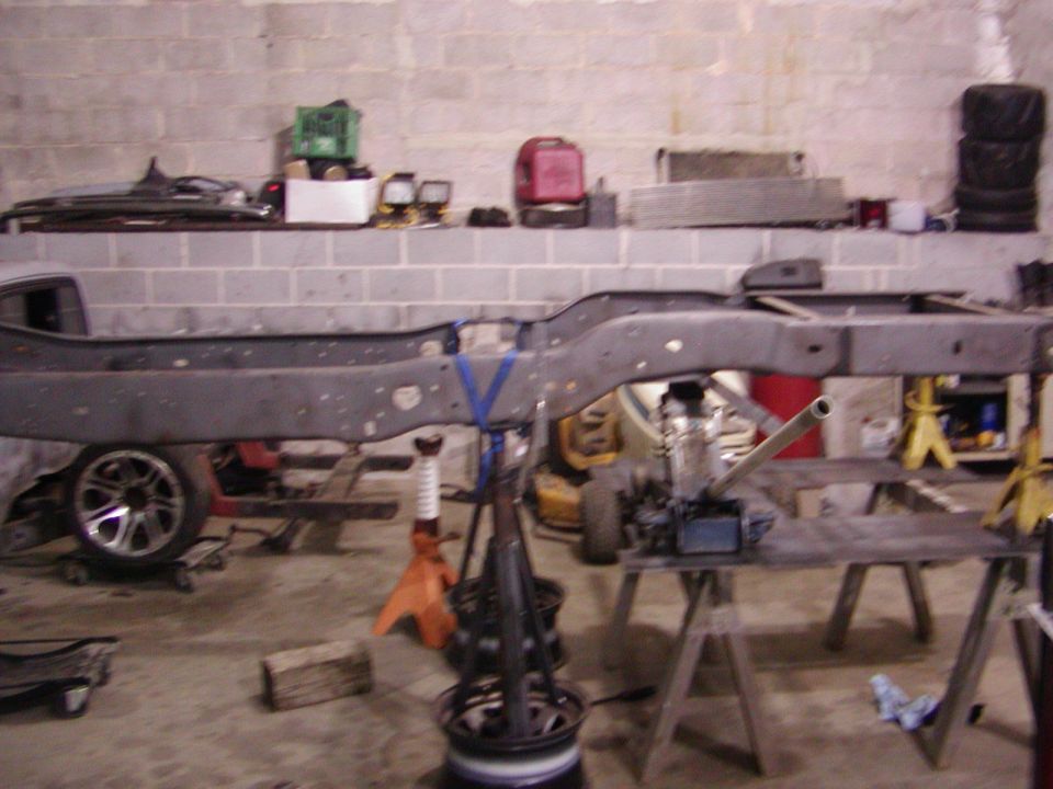 Vehicle frame on stands, with a wheel visible on the left