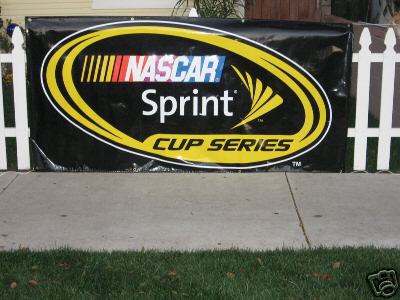 1993 Ford C-350 (Centurion Conversions) - A large black banner displaying the NASCAR Sprint Cup Series logo is displayed outdoors.