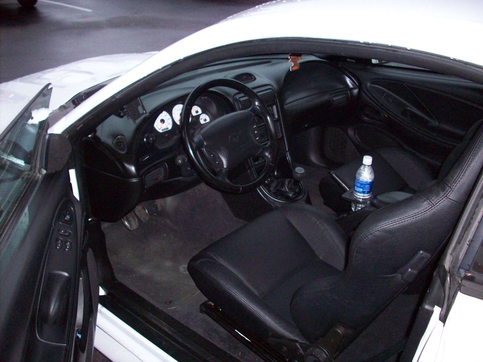 Interior of a 1997 Ford Mustang, showing black leather seats and dashboard