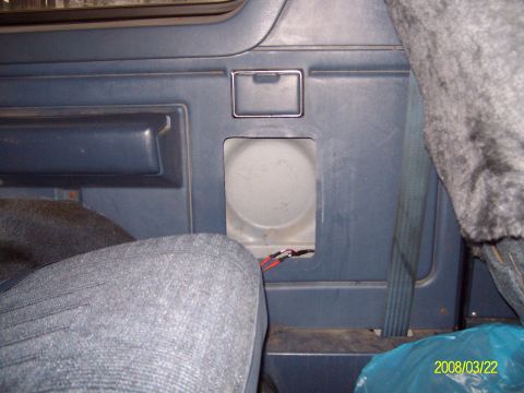 1988 Ford Bronco - Rear driver-side interior quarter panel of a blue truck cab with the trim cut open to expose a white speaker mounting recess, red and black…