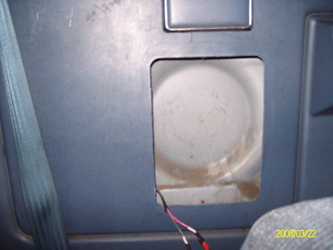 1988 Ford Bronco - Blue interior side trim panel with the speaker grille removed, showing an empty rectangular cutout down to the white-painted body sheetmeta…