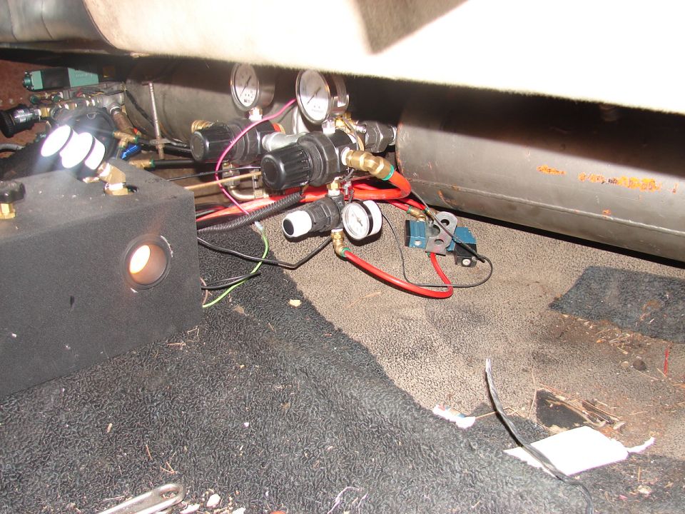 Onboard air system with tank, twin pressure gauges, regulators, and red air lines installed behind a seat