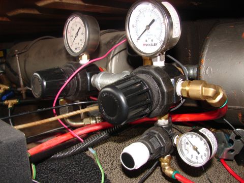 1973 Ford Ranchero - Close-up of an air system control manifold with black knurled pressure regulators, brass fittings and a Weksler 0-200 PSI gauge alongside t…