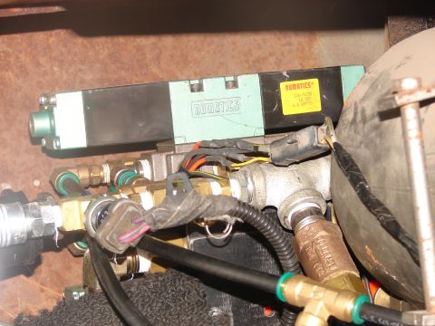 1973 Ford Ranchero - A Numatics 12 VDC solenoid air valve (part 226-503B) mounted to a rusty frame rail, plumbed with brass fittings, braided and rubber air lin…