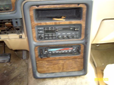 1986 Mercury Cougar - Interior view of a car dashboard wood trim and a dual DIN car stereo system.