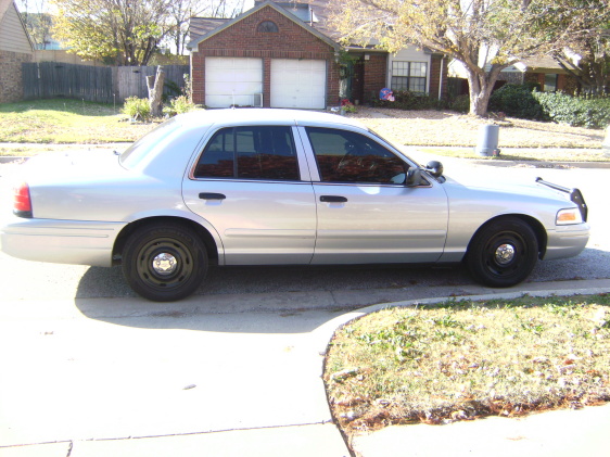 Silver 2003 Ford Crown Victoria sedan, side view, parked on a suburban street
