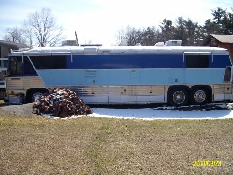 1988 Ford Bronco - This motorhome has a two-tone blue and silver exterior with multiple windows and storage compartments.