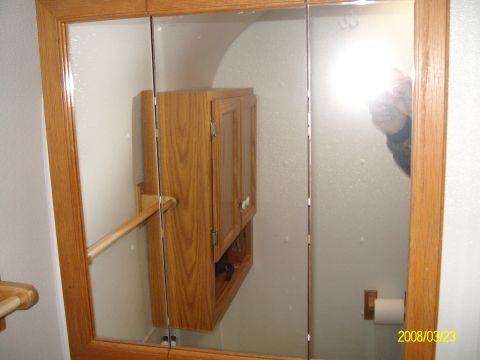 1988 Ford Bronco - This image shows the interior of a motorhome bathroom, wooden cabinets and mirrored doors.