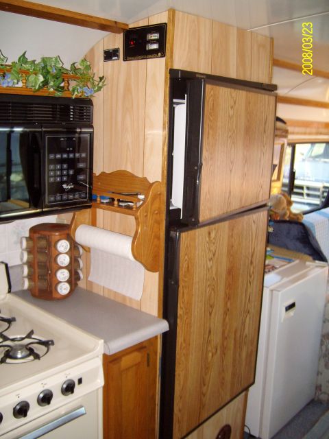 1988 Ford Bronco - Interior view of an RV kitchen wood-paneled walls and appliances.