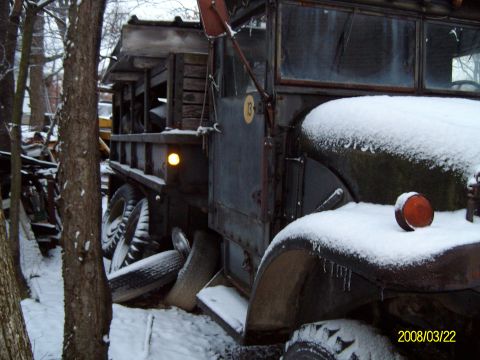 1988 Ford Bronco - A weathered dump truck sits in a snowy, wooded area, showing its age and utility.