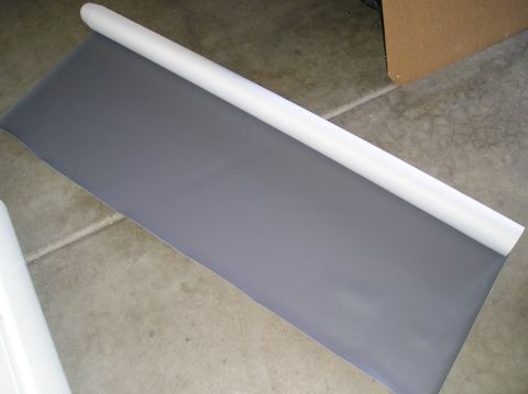 1986 Toyota Hilux - A roll of grey material is laid out on a concrete surface, with a white tube forming the core of the roll.