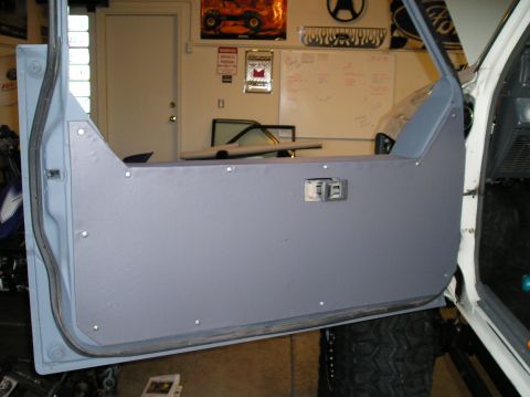 1986 Toyota Hilux - Custom door panel installed inside a vehicle, with a large tire visible underneath.