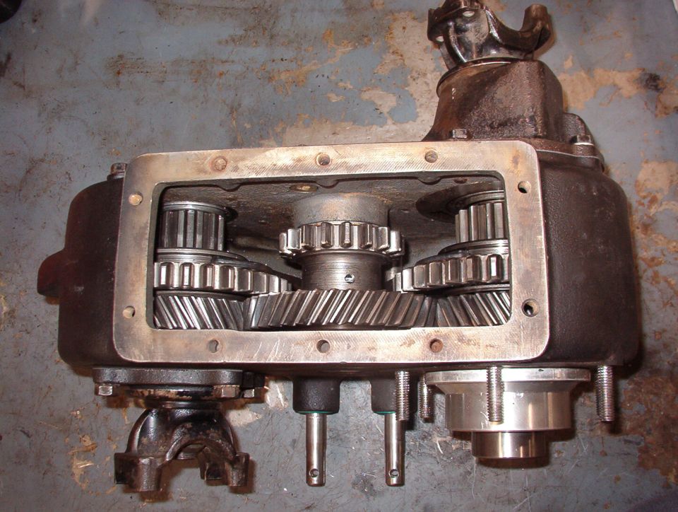 4WD High
Both sliding gears (and the shift rails) are full forward, locking both outputs to the hi-speed (1:1)set of gears at the front of the case.  The pills prevent the rear output shift rail from moving; only the front can move rearward to neutral.

The Aluminum sleeve & stub shaft at the lower R are for the Advance Adapters kit for the AOD.  Removing that shaft from the t-case allows about a dozen roller bearings to fall loose into & out of the t-case.  Finding & re-installing them is a challenge.