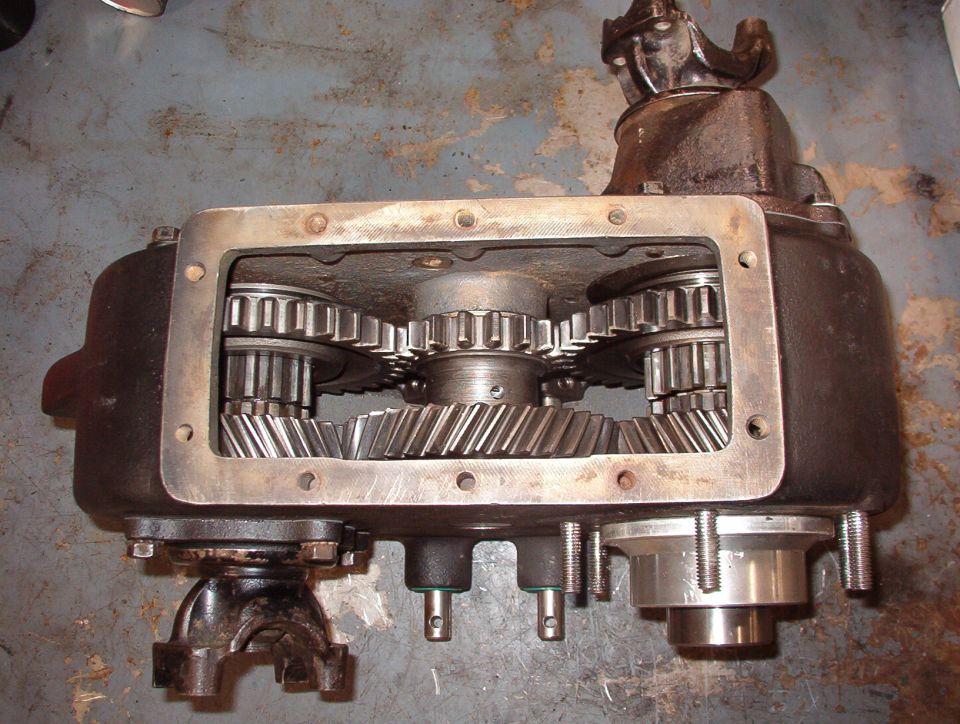 4WD Low
Both sliding gears (and the shift rails) are full rearward, locking both outputs to the small end (low range) of the center idler gear.  The pills prevent the rear output shift rail from moving; only the front can move forward to neutral.

The Aluminum sleeve & stub shaft at the lower R are for the Advance Adapters kit for the AOD.  Removing that shaft from the t-case allows about a dozen roller bearings to fall loose into & out of the t-case.  Finding & re-installing them is a challenge.