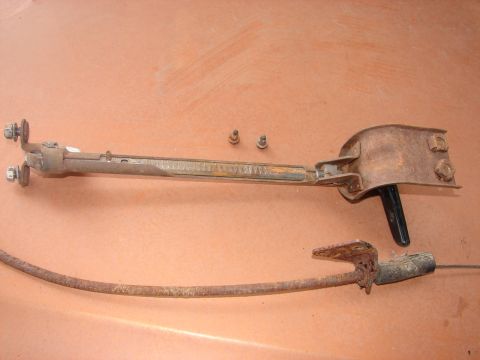 1973 Ford Ranchero - Rusted car part assembly with cable and black handle, likely from an older vehicle.