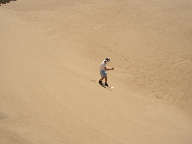 Riding an old snow board in sand