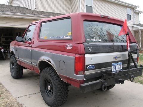 1995 Ford Bronco - Ford Bronco with off-road modifications, including large tires and a rear bumper.