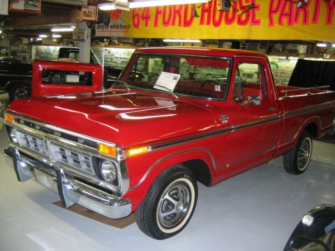 1992 Ford Mustang - A red 1977 Ford F-150 pickup truck is displayed indoors, possibly at a museum or dealership.