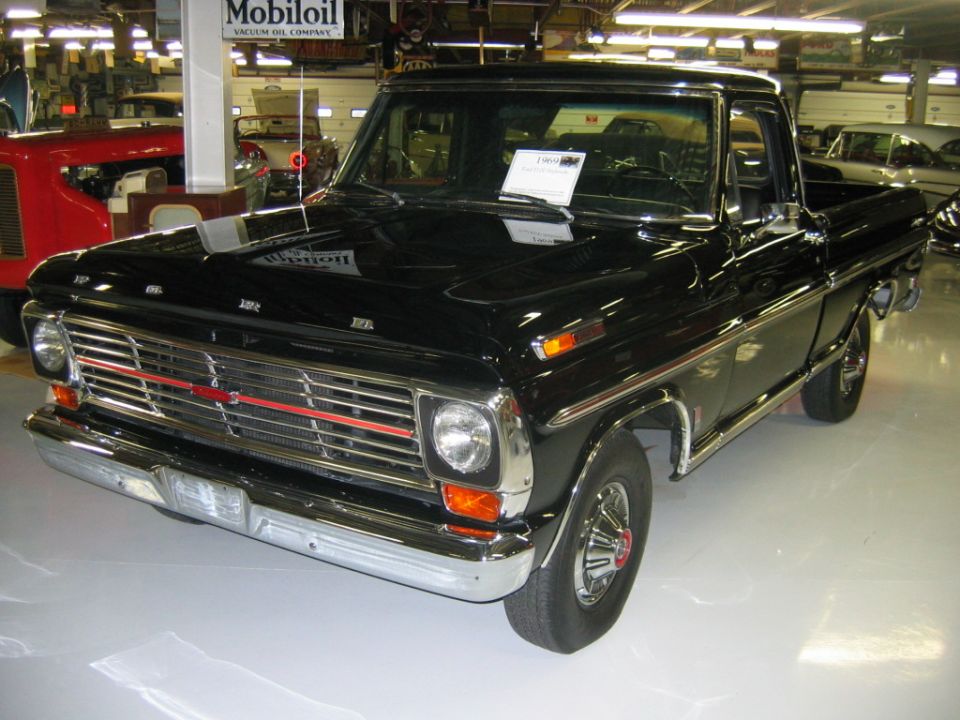 Black 1969 Ford F-Series pickup truck, front view, chrome grille with red accent