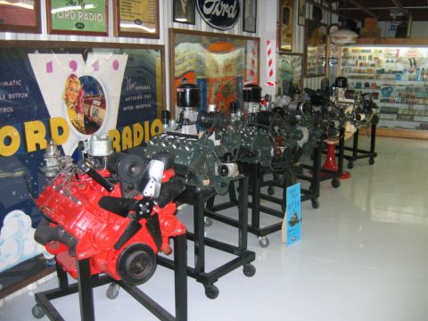 1992 Ford Mustang - Several Ford V8 engines are displayed on stands in what appears to be a museum or showroom.