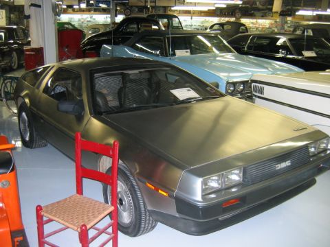 1992 Ford Mustang - DeLorean DMC-12 parked indoors with other classic cars visible in the background.