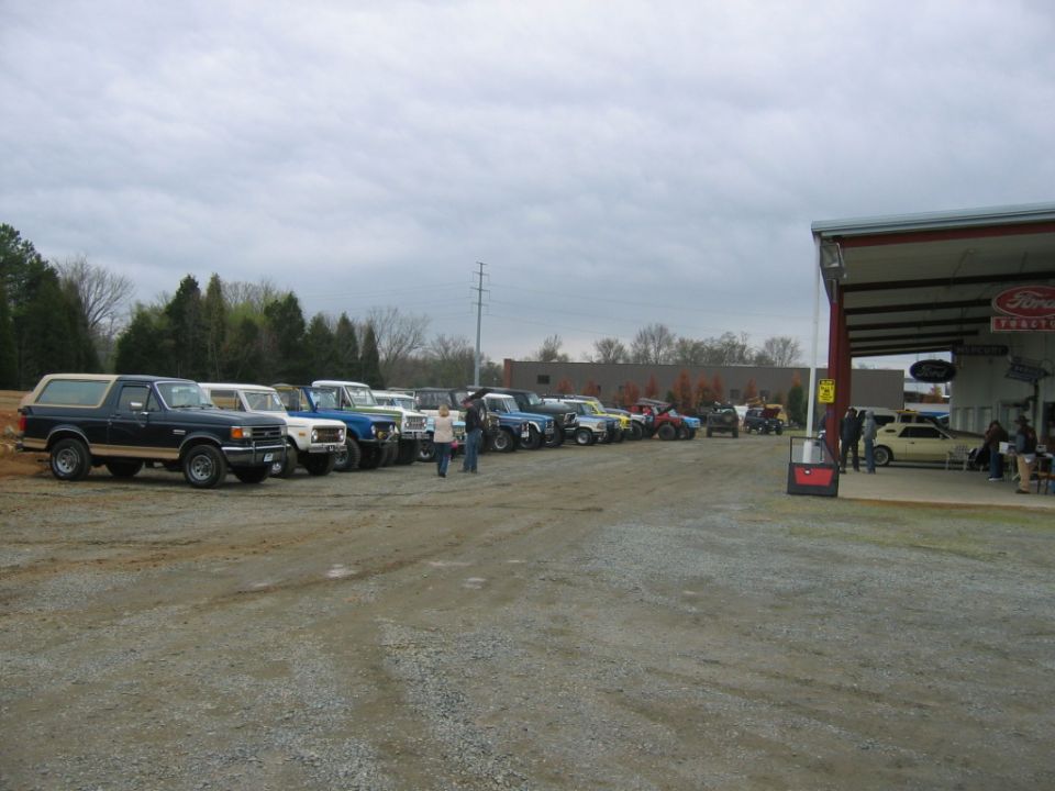 Line of Ford Broncos and trucks parked outside a Ford dealership