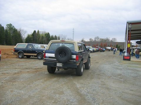 1992 Ford Mustang - Several Ford Broncos and other vehicles are parked in a lot on a cloudy day.