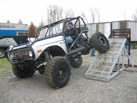 1992 Ford Mustang - Customized Ford Bronco with extreme off-road modifications is positioned on a ramp.