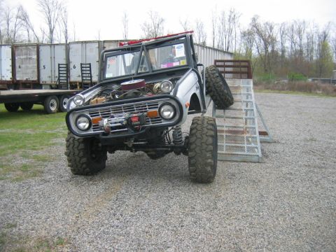 1992 Ford Mustang - This heavily modified SUV is positioned on a metal ramp, with its hood open, revealing the engine components.