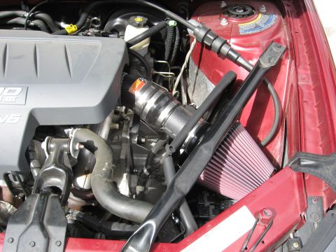 2004 Pontiac Grand Prix - The engine bay of a red 2004 Pontiac Grand Prix shows a V6 engine with an aftermarket air intake.