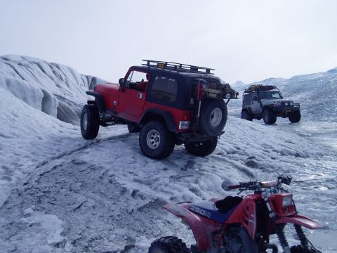 2000 Ford E350 - Multiple off-road vehicles navigate a glacial landscape under a clear sky.