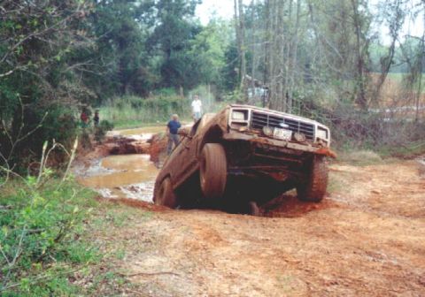 1984 Ford Bronco - This Ford Bronco appears to be stuck in a muddy ditch on a dirt road.
