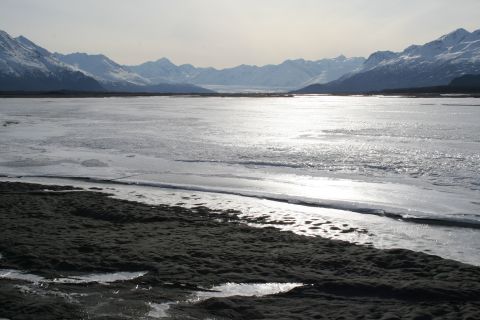 2003 Jeep TJ - A vast, icy landscape stretches towards snow-capped mountains under a hazy sky.