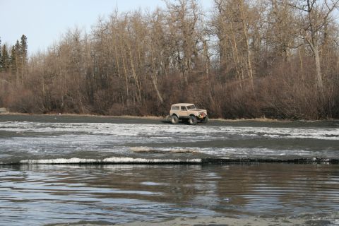 2003 Jeep TJ - SUV parked near water with bare trees in the background.