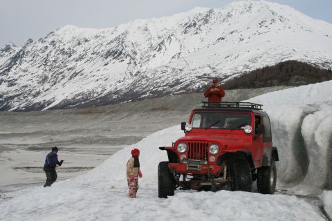 2003 Jeep TJ - Red 2003 Jeep TJ parked on snow with people nearby, mountains in the background.