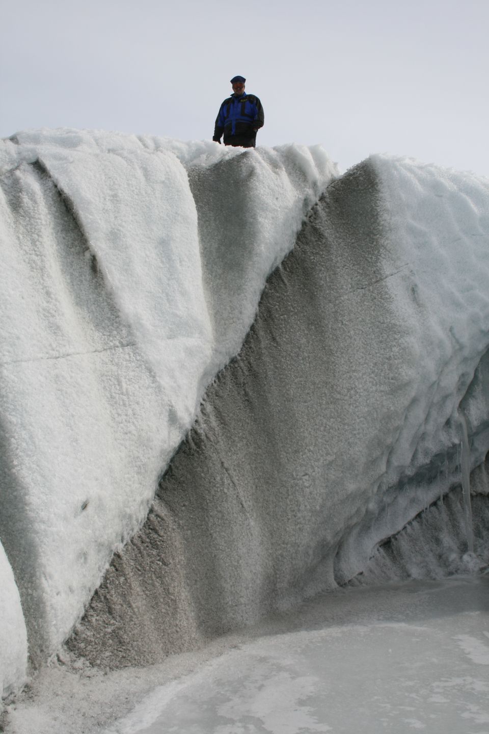 Person standing on a glacier with icy formations