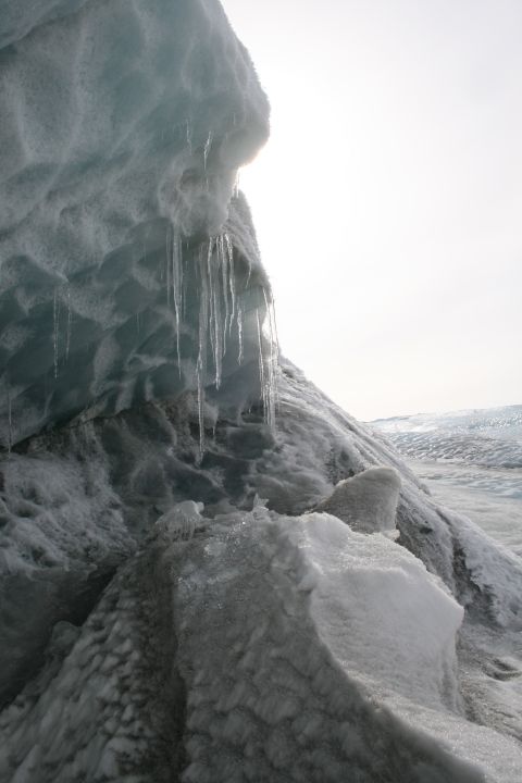 2003 Jeep TJ - Icicles drip from a massive ice formation under a bright sky, suggesting a melting glacier.