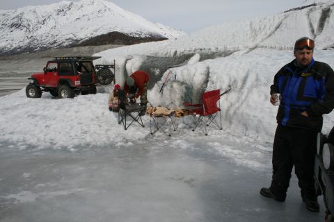 2003 Jeep TJ - People and a red Jeep TJ on a glacier, with snowy mountains in the background.