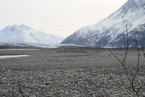 2003 Jeep TJ - A wide, rocky valley stretches towards a distant glacier, framed by imposing snow-covered mountains.