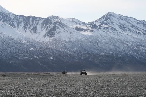 2003 Jeep TJ - Two 2003 Jeep TJs traverse a rocky, dusty plain beneath a mountain range.