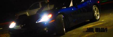 2005 Chevrolet Corvette - Blue 2005 Chevrolet Corvette and white pickup truck seen at night with text overlay.