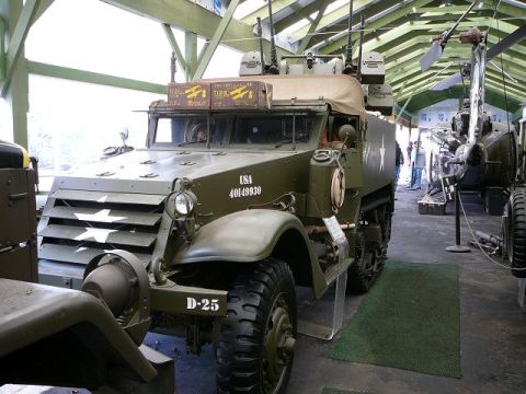 1997 Mercury Grand Marquis - An olive drab half-track military vehicle, likely from WWII, is displayed indoors with other military equipment. Markings include 'USA 4014…