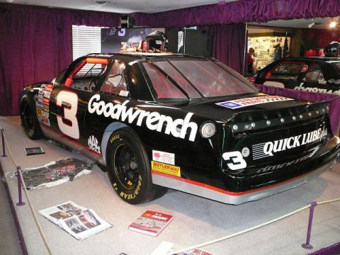 1997 Mercury Grand Marquis - A black race car with prominent "Goodwrench" sponsorship and the number 3 is displayed indoors.
