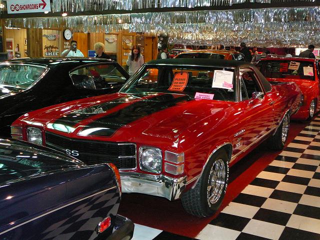 Red 1970 Chevrolet El Camino SS with black racing stripes, chrome wheels, and a black vinyl top