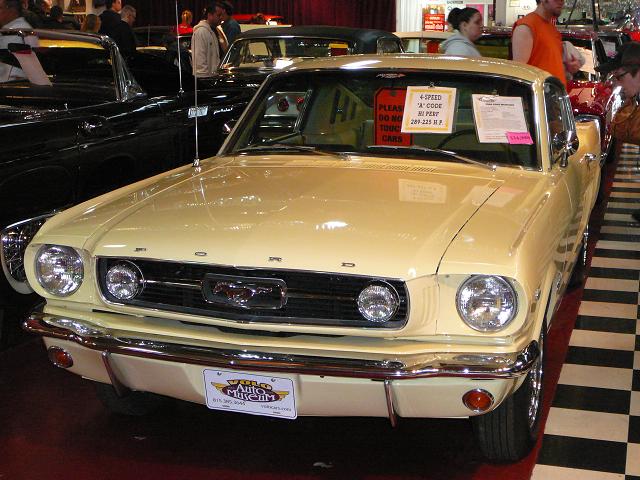 Yellow 1965 Ford Mustang coupe with a "Volo Auto Museum" plate